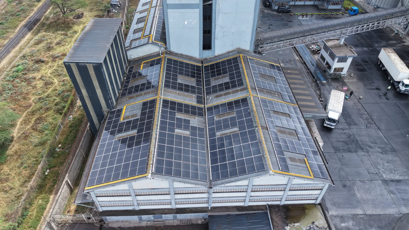 Close aerial view of solar panel rows on the pitched roof of the Kabansora Millers mill building