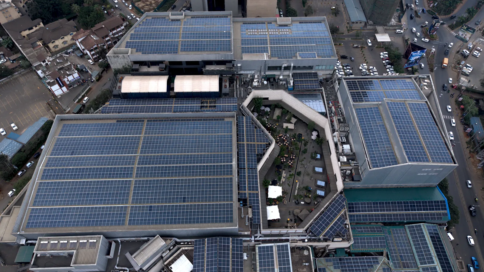 Overhead drone view of solar panel arrays covering the main roof sections of Sarit Centre, Nairobi